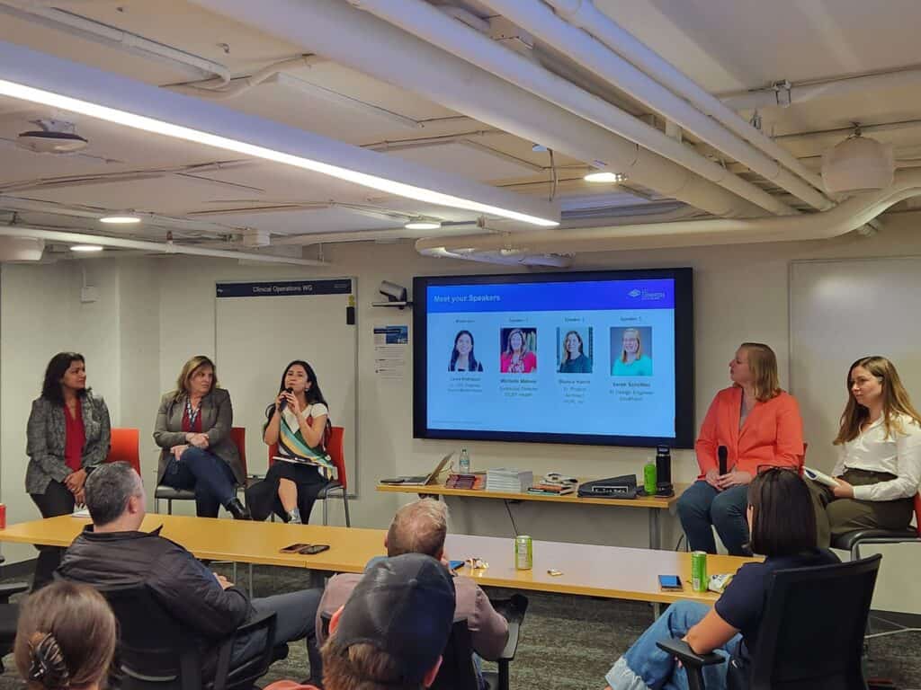 Group of people on a panel in the front of a room.